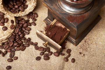 still life of coffee beans in jute bags with coffee grinder
