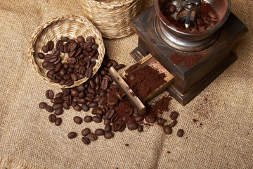still life of coffee beans in jute bags with coffee grinder