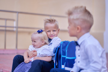 two brothers pupils with infanta sister are waiting for mom near school