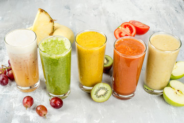 Smoothie made of grapes, pineapple, kiwi, tomato, apple shot from the side