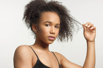 closeup portrait of young mixed race model with curly hair in studio with natural neutral makeup...