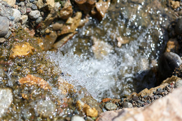 splashes and drops of a stream running over stones