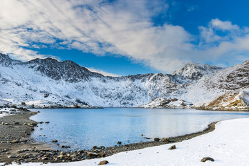 Snow covered mountain range and blue lakes in snowdonia, wales, United Kingdom.