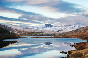 Fototapeta na wymiar Snow covered mountain range and blue lakes in snowdonia, wales, United Kingdom.