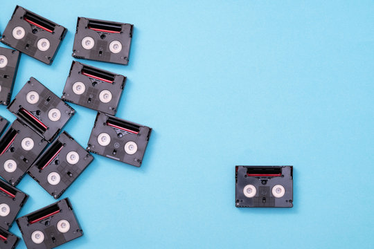 Vintage mini DV cassette tapes used for filming back in a day. Pattern made of plastic video tapes on blue background