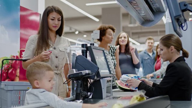Woman paying with a smart watches in a grocery store