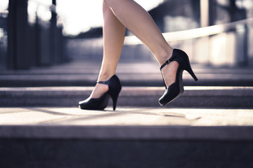Woman walking in high heels in urban city street in summer. Chic stylish footwear. Elegant fashion...