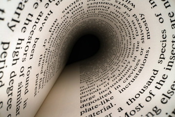 Inside the book concept. Latin letters and words on an tunnel shaped, perspective book page with black dramatic light. Education, knowledge concept