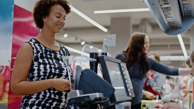 Black woman buying goods in a grocery store.