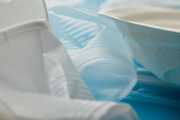 close up view of crumpled plastic cups on blue background