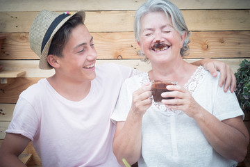 beautiful couple of people having fun and joking together with a grandma drinking hot chocolate and...