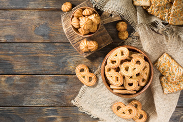 Cookies in wooden bowls on a wooden table. Top view