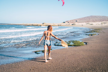 a lonely girl is walking on the sand at the beach with a cap in her hand along island coastline and...