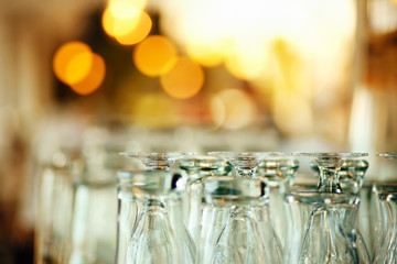 Empty glasses for beer on a bar rack waiting for the party
