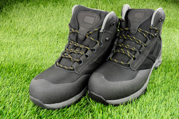 Pair of new work safety protection boots on an artificial grass background