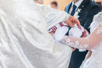 Obraz na płótnie Canvas Priest ties towel the hands of the bridegroom