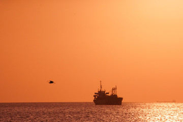 Obraz premium Ship silhouette and sunset