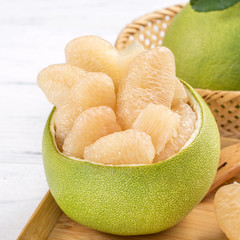 Fresh peeled pomelo, pummelo, grapefruit, shaddock on bright wooden table background. Seasonal fruit for Mid-Autumn Festival, close up, copy space.