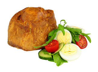 Crusty handmade savoury pork pie with salad and boiled egg isolated on a white background