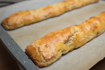 Tray of freshly home baked Italian tozzetti/cantucci biscuits before slicing, closeup.