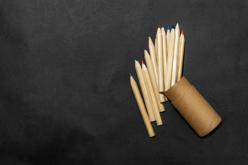 Top view many color crayons pastels on dark background.