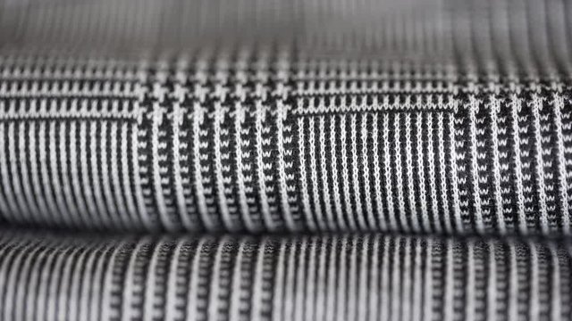Super macro closeup shot of elegant houndstooth pied de poule fabric folded and laid on a clothing shop or in a tailor's. Fashion concept.