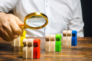 Groups of multicolored wooden people and businessman. The concept of market segmentation. Target...