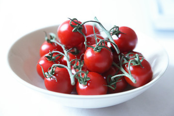 Red ripe tomatoes in white bowl
