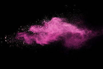 Pink powder explosion on black background. Paint Holi.