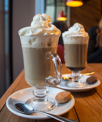 cup of coffee with whipped cream on wooden background