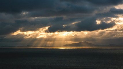 Naklejka na ściany i meble Beautiful seascape splitting rays cloudy clouds sun light sunset Scotland Neist Point