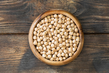Chickpeas in a wooden bowl on a wooden table. Rustic style