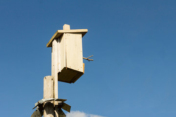 wooden birdhouse against the blue sky