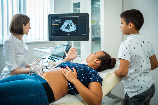 Pregnant woman and her son on utltrasonographic examination at hospital