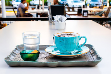 Cappuccino served in stylish way with delicious cookie and glass of water
