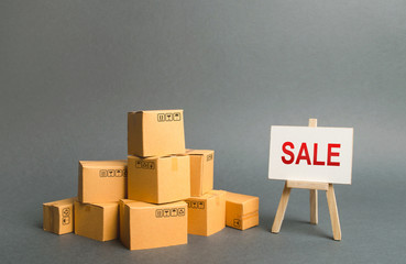 A pile of cardboard boxes and stand with the word sale. sale of products, discounts on goods of the outgoing season. commodity exchange with other countries. Advertising campaign to attract customers.