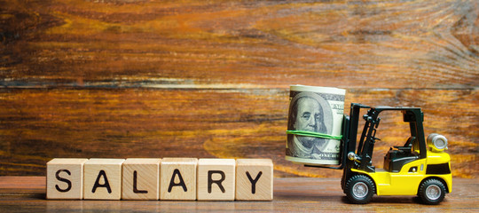 Yellow forklift truck carries a bundle of dollars to the inscription Salary. Salary and wage...