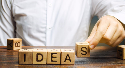 Wooden blocks with the word Ideas and businessman. Generation of innovative business ideas. Creative process. Business strategy and startup. Plan. Planning