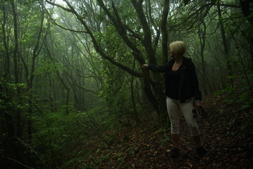Mulher aponta o caminho de entrada para a floresta