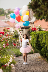 Girl with colorful latex balloons in the park