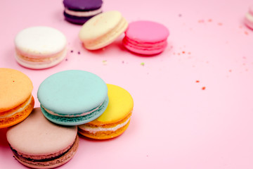 Fototapeta na wymiar Colorful french macarons (macaroons) cake, delicious sweet dessert on a pink background with copyspace, food background concept.