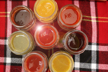 Small jars with colored sauces. Dip. Colorful jars pattern. Chili. Guacamole.