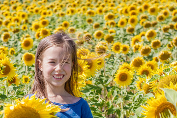 Sweet litle girl in sunflower field