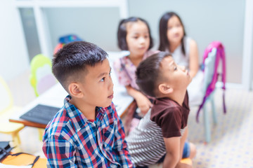 Asian elementary school children are studying and having fun in the classroom.