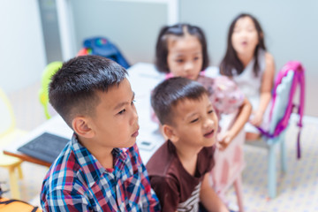 Asian elementary school children are studying and having fun in the classroom.