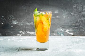 Tasty peach tea in glass on the rustic background. Selective focus. Shallow depth of field.