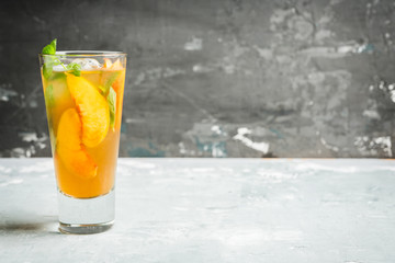 Tasty peach tea in glass on the rustic background. Selective focus. Shallow depth of field.