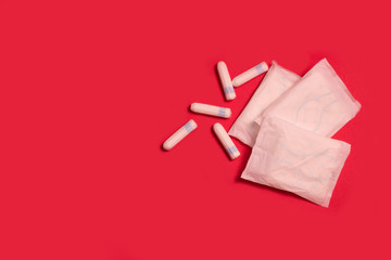 sanitary tampons and pads on a red background