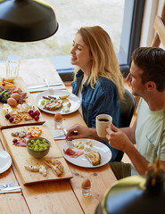 Cheerful couple doing breakfast