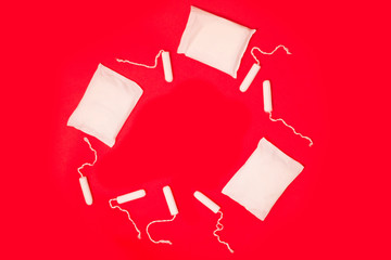 sanitary tampons and pads on a red background